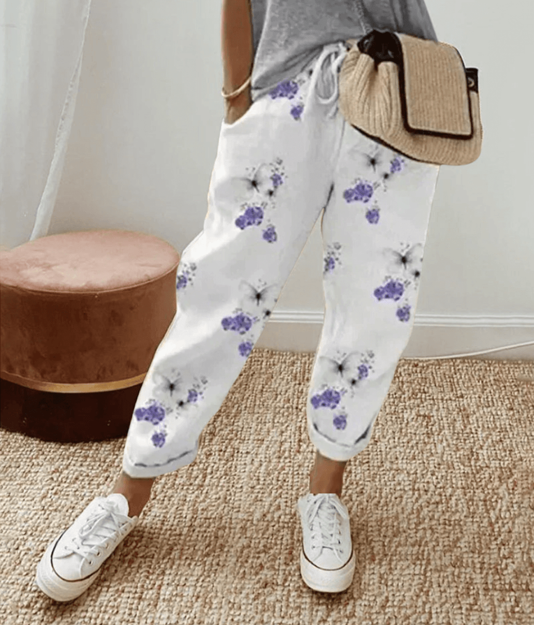 Pantalon blanc à fleurs violettes, taille élastique avec cordon, bas retroussé.