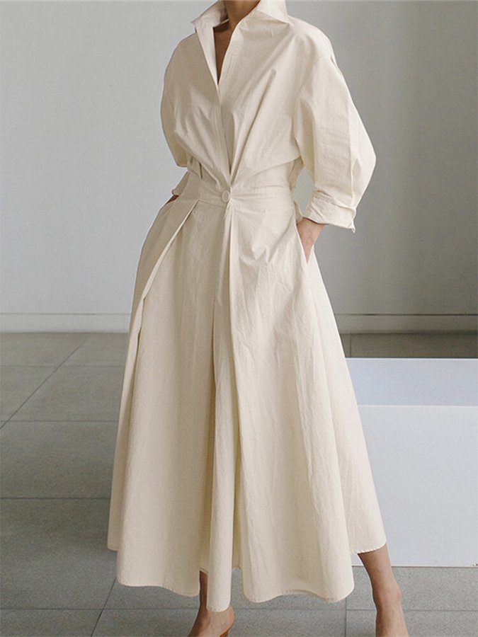 Robe longue écru à col chemise, manches bouffantes et ceinture nouée.