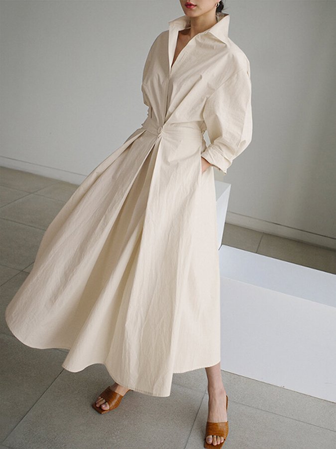 Robe longue beige à col chemise, manches bouffantes et ceinture nouée.