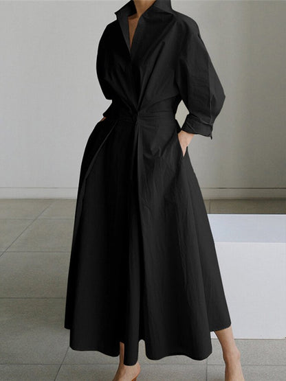 Robe longue noire à encolure V, manches bouffantes et ceinture à nouer.