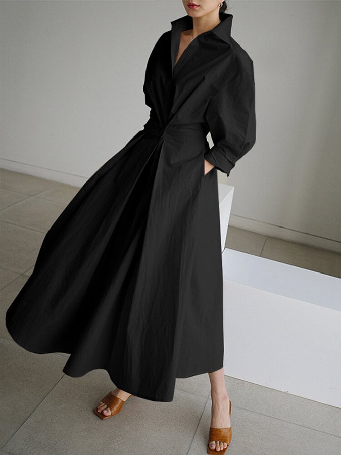 Robe longue noire à col chemise, manches bouffantes et ceinture nouée.