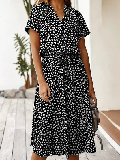 Robe fluide midi à manches courtes, imprimé motifs blancs sur fond noir, col boutonné, ceinture