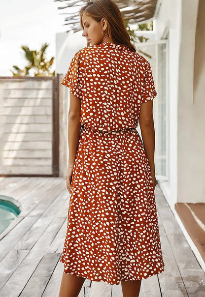 Robe fluide midi orange terre cuite à motif taches blanches, col V, manches courtes.