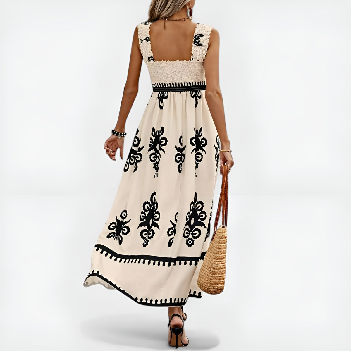 Robe d’été beige sans manches, encolure carrée dos nu, broderies noires et volant festonné.