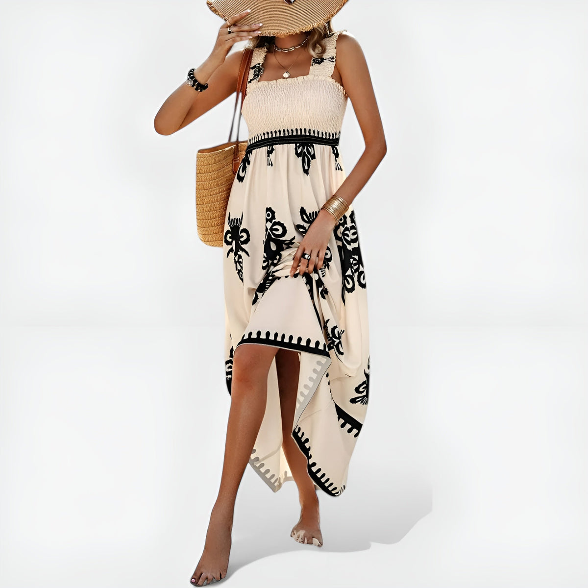 Robe d’été beige sans manches, motif noir sur fond clair, franges et base asymétrique.