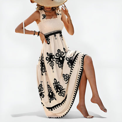 Robe d’été beige sans manches, motif floral noir, base large avec bordure contrastée.