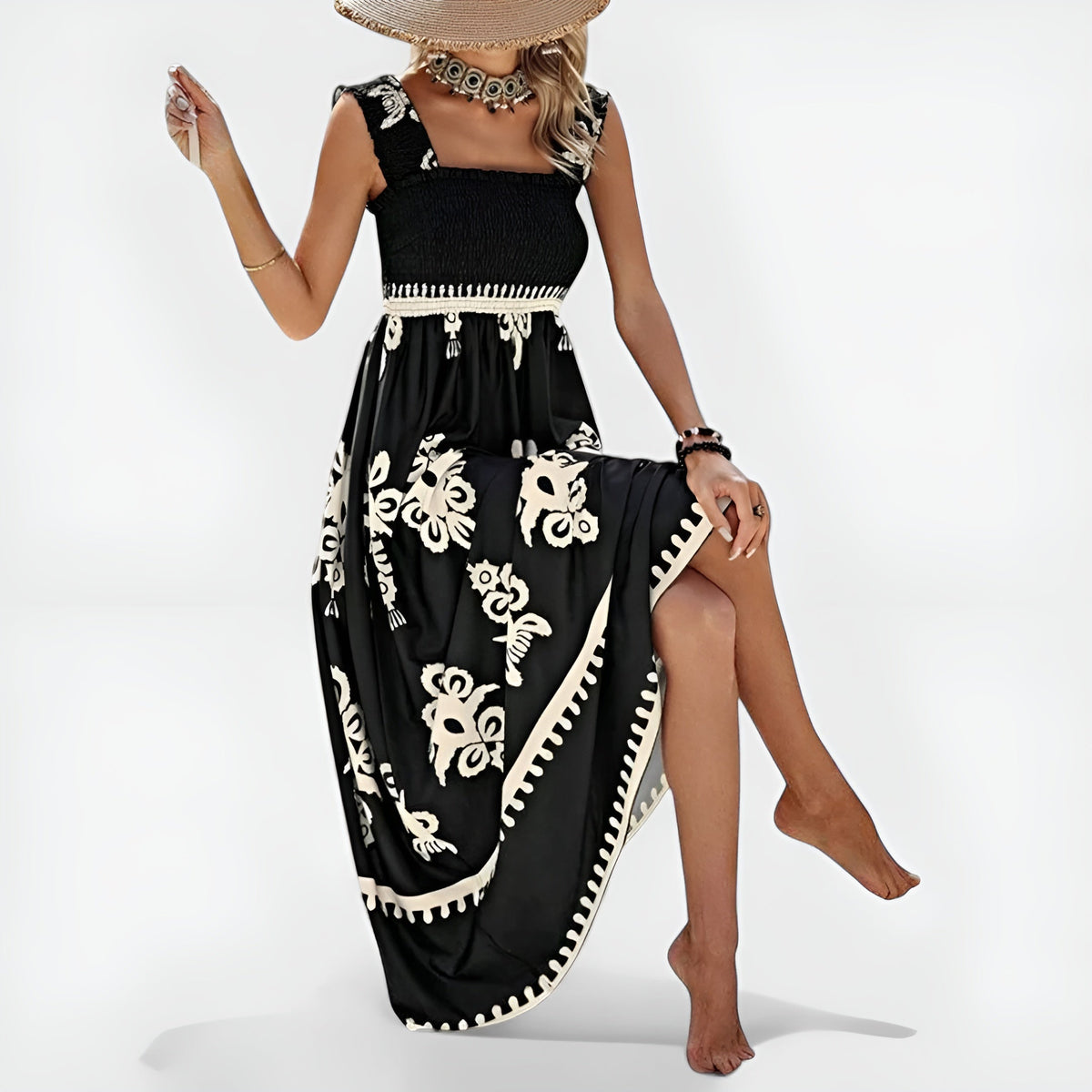 Robe d’été noire sans manches, encolure carrée, motifs blancs baroques et ourlet festonné.