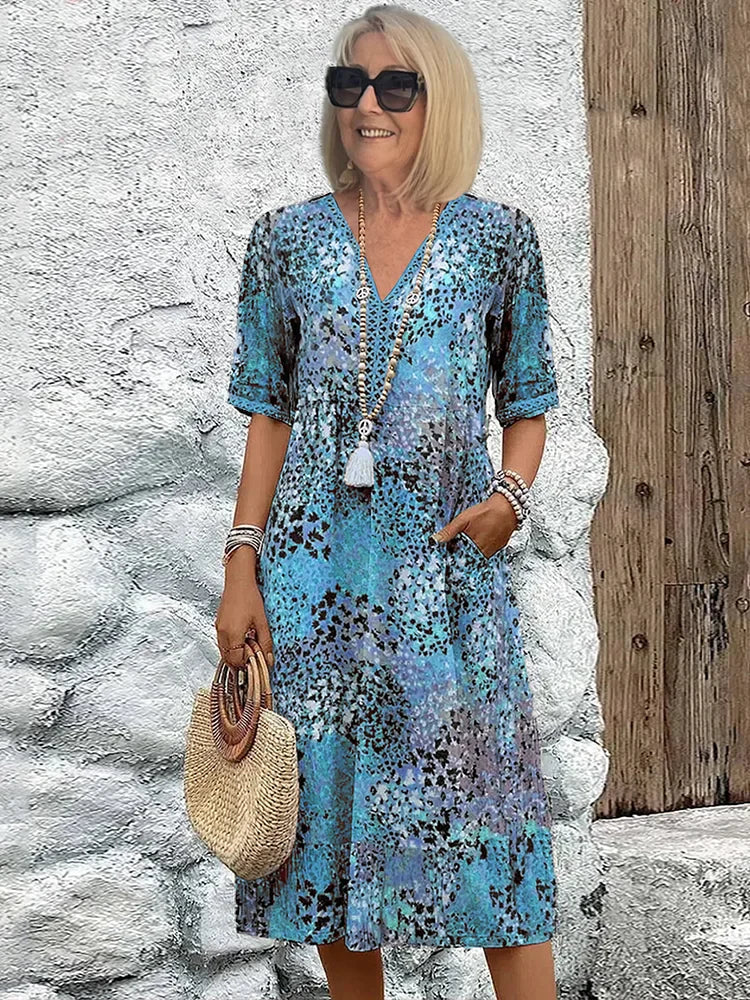Robe midi bleu océan à motif, décolleté V, manches courtes boutonnées et pompon