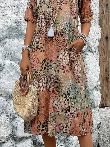 Robe midi motif multicolore, manches courtes, boutons devant et pompon blanc pendentif
