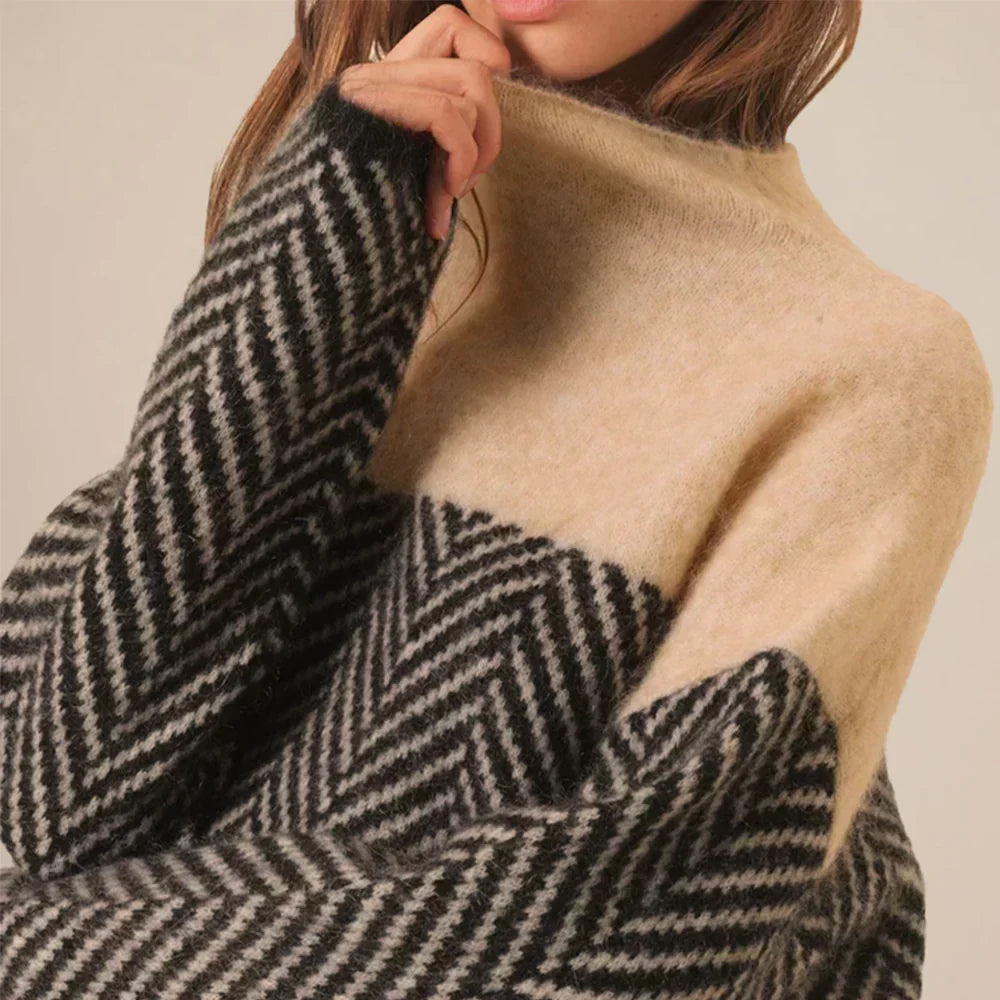 Haut de pull beige, col montant, motif chevrons noir et blanc en maille texturée.