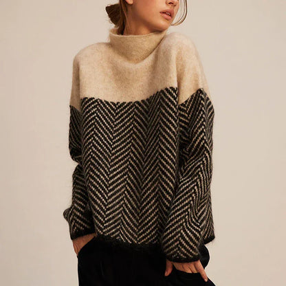 Pull beige et noir à col montant, motif chevrons en maille torsadée, manches longues.