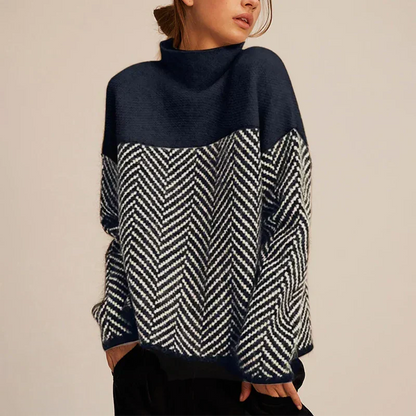 Pull bleu marine et noir, col montant, motif chevrons contrasté, manches longues.