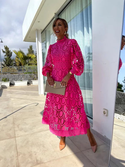 Robe en dentelle romantique rose fuchsia, manches longues et col rond, motif festonné.