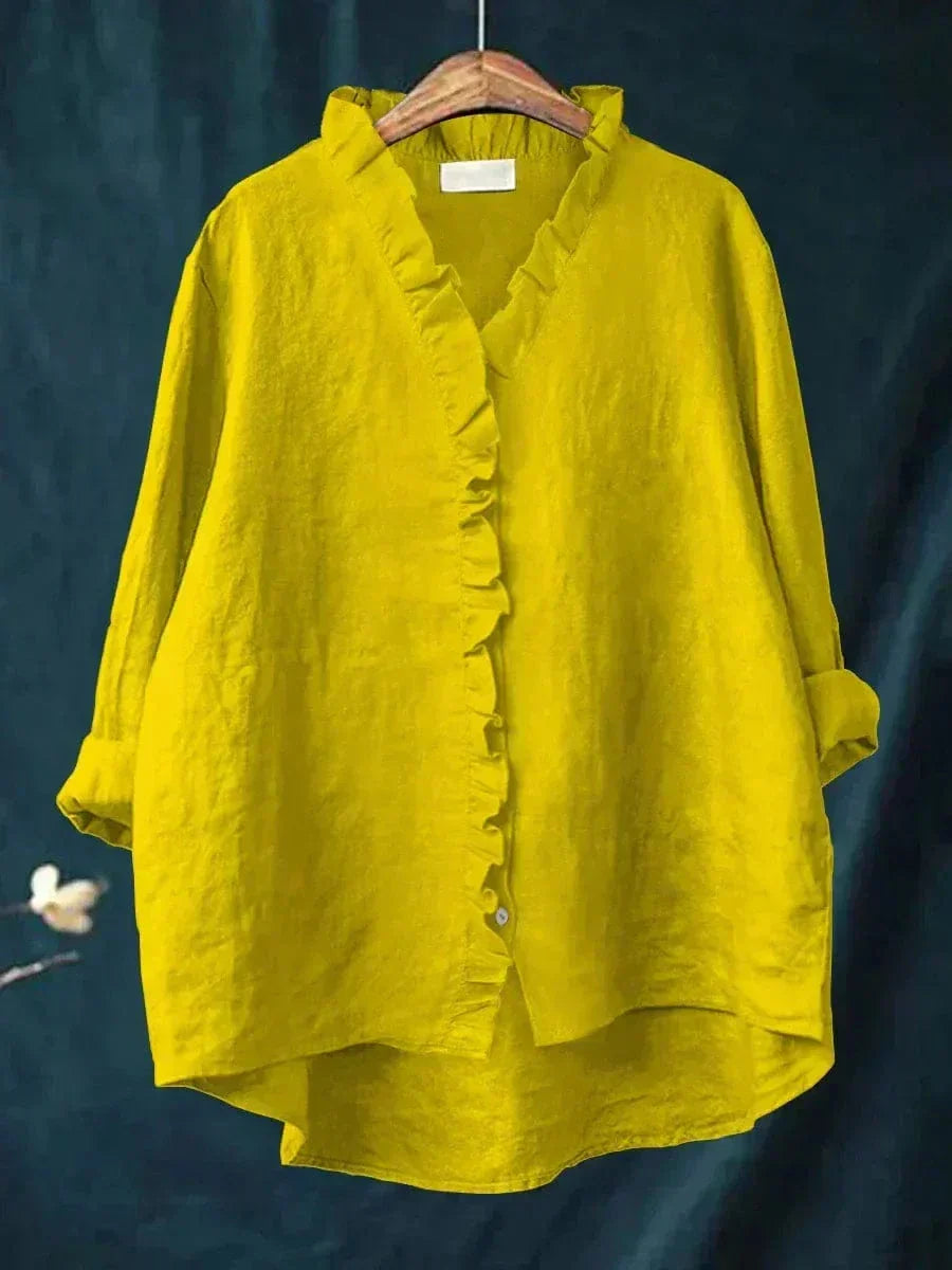 Blouse jaune à encolure V, volants boutonnés et manches longues froncées.