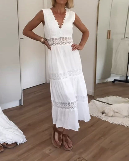 Robe d'été blanche sans manches, jupe évasée à volants et empiècements dentelés.
