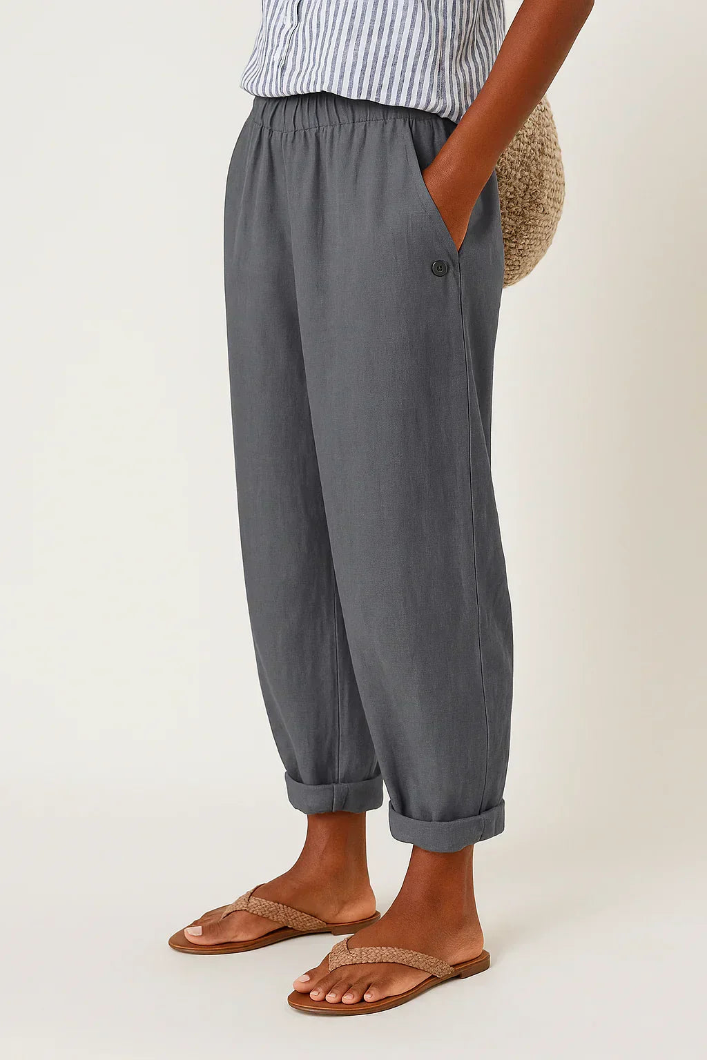 Pantalon en lin-coton gris, taille élastique, ourlets retroussés, bouton décoratif.