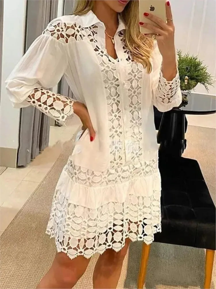 Robe courte blanche en dentelle ajourée, encolure V, manches bouffantes.