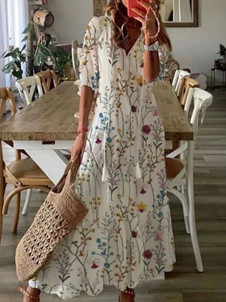 Robe maxi blanche à fleurs et tiges, encolure V, manches mi-longues, coupe ample.