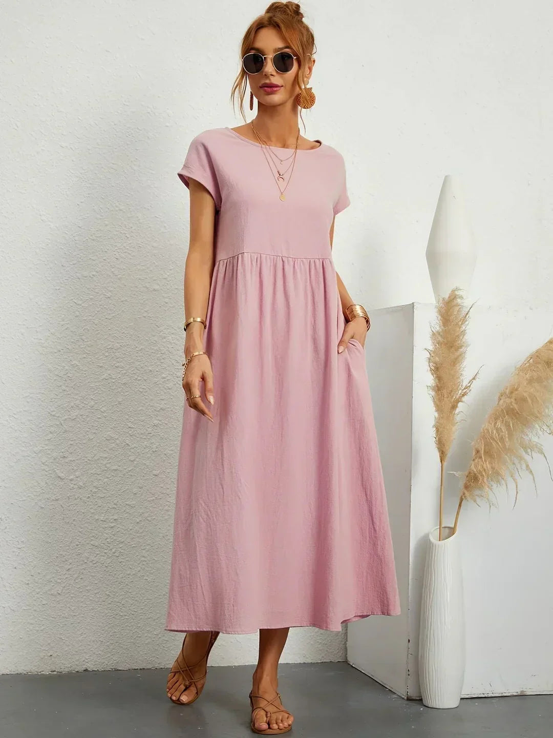 Robe midi fluide rose, manches courtes, encolure ronde, taille froncée ample.