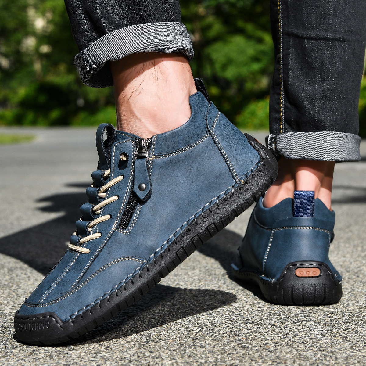 Chaussure nubuck bleu zippée portée, lacets et semelle épaisse sur sol extérieur