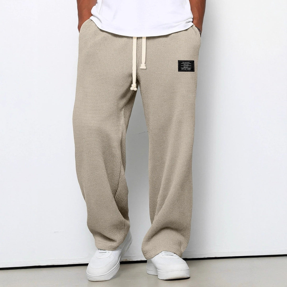 Pantalon large kaki à taille réglable, cordon à la ceinture, jambe ample, tissu texturé.