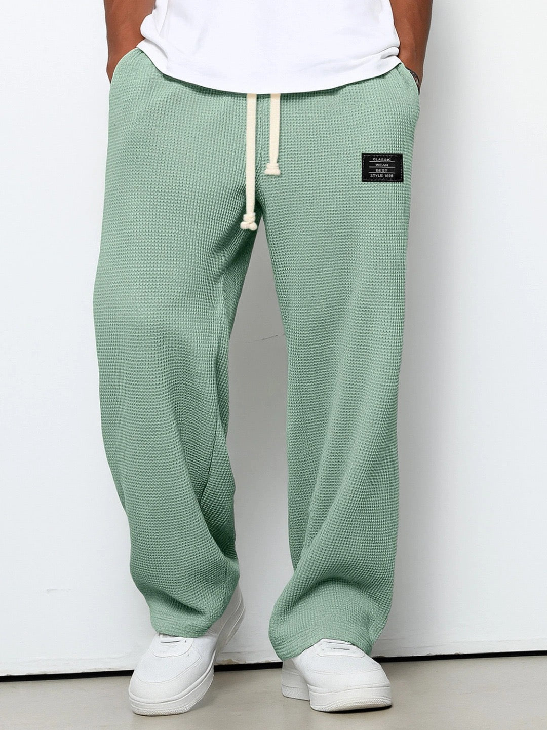 Pantalon large vert à taille réglable, cordon à la ceinture, jambe ample, tissu texturé.