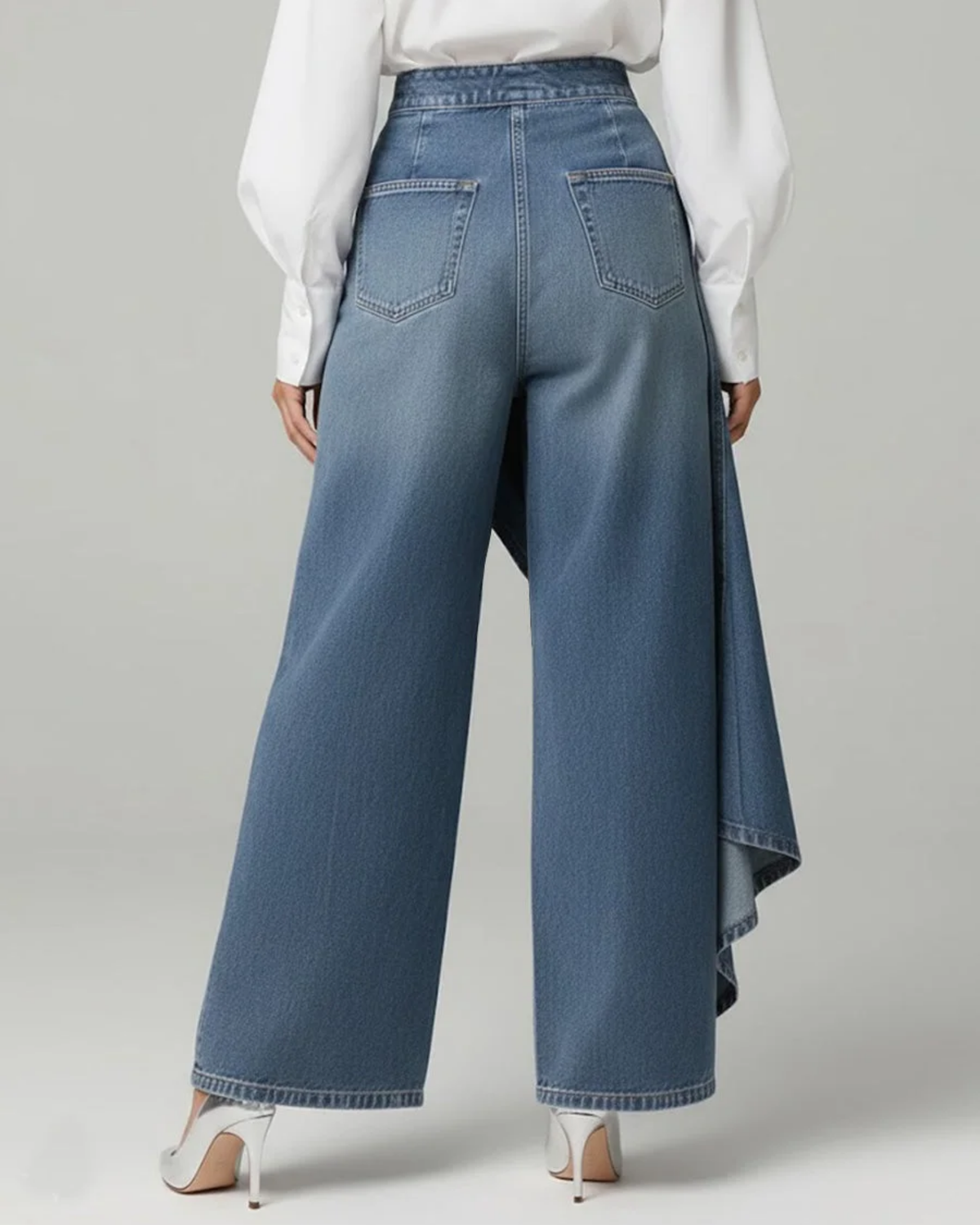 Jeans bleu clair à jambes larges, drapé asymétrique et boutons en patte.