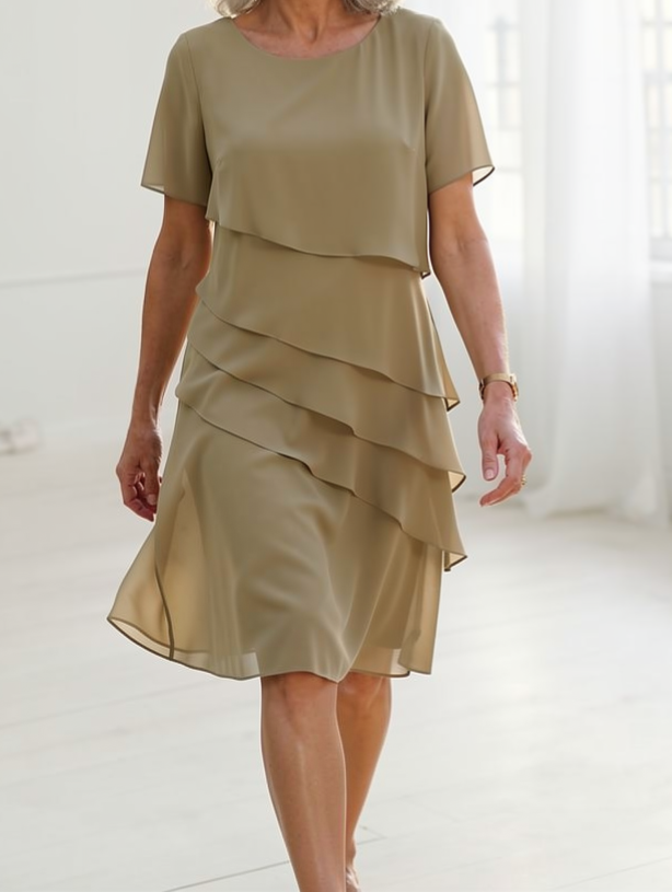Robe fluide beige à volants superposés, manches courtes, jupe mi-longue.