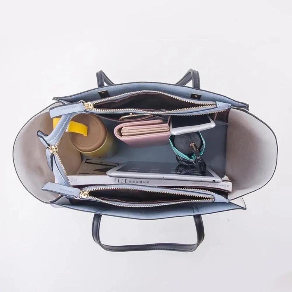 Grand sac cabas bleu ouvert, vue intérieure avec objets et poches zippées