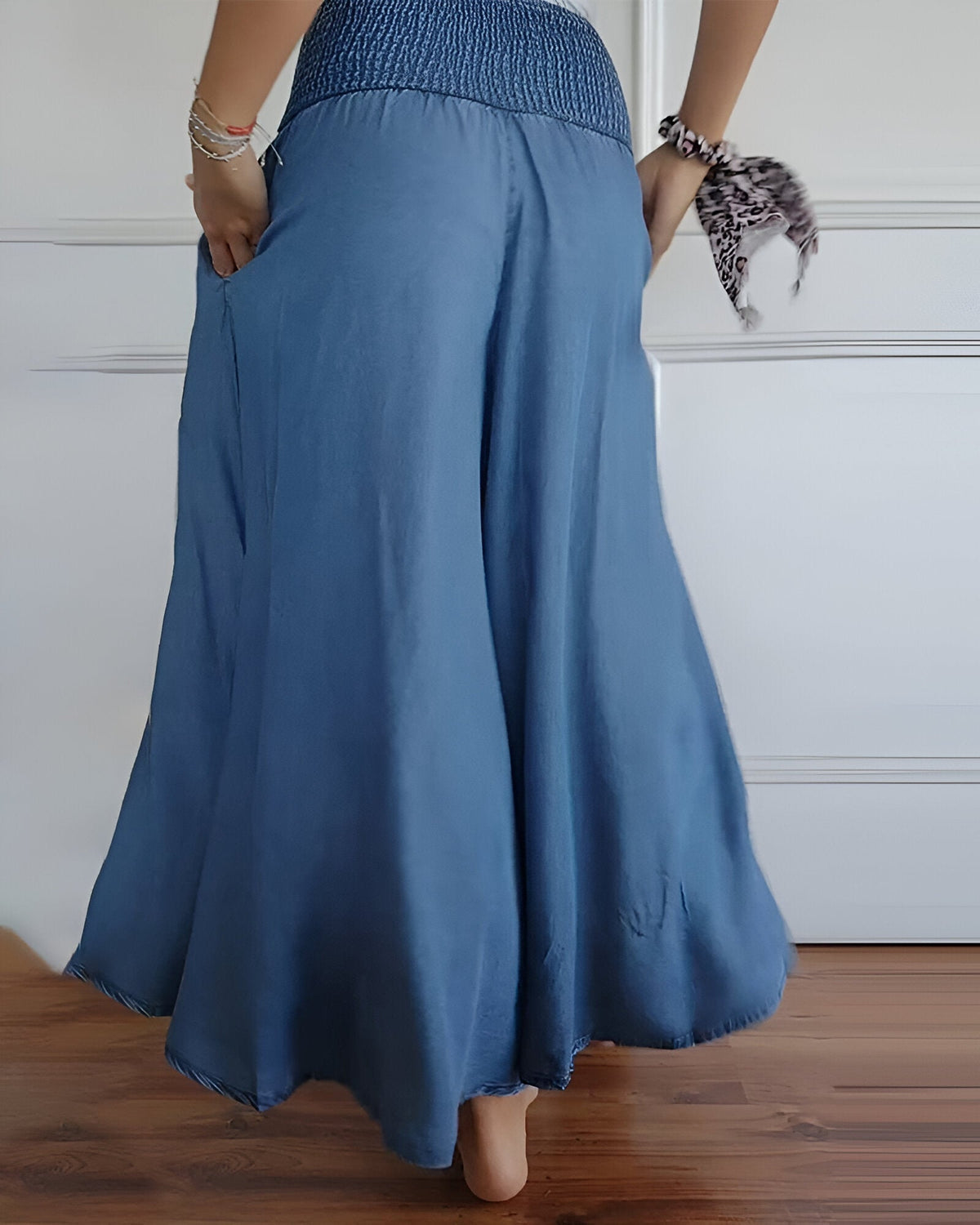 Pantalon fluide bleu à taille froncée, volume ample et plis sur la jambe.