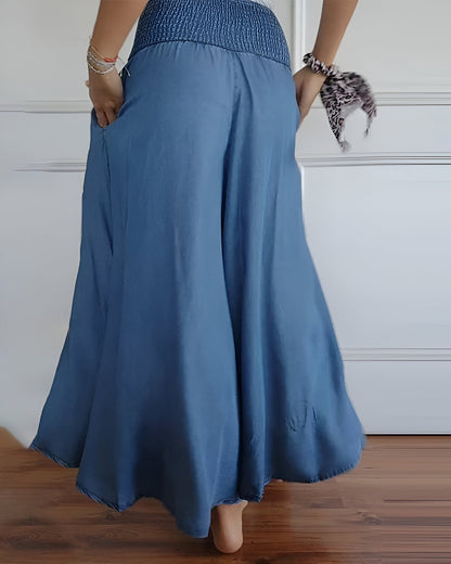 Pantalon fluide bleu à taille froncée, volume ample et plis sur la jambe.