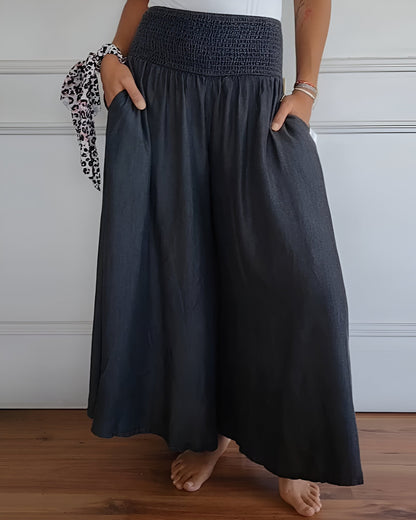 Pantalon fluide gris foncé à taille élastique froncée, volume ample sur tout le bas.