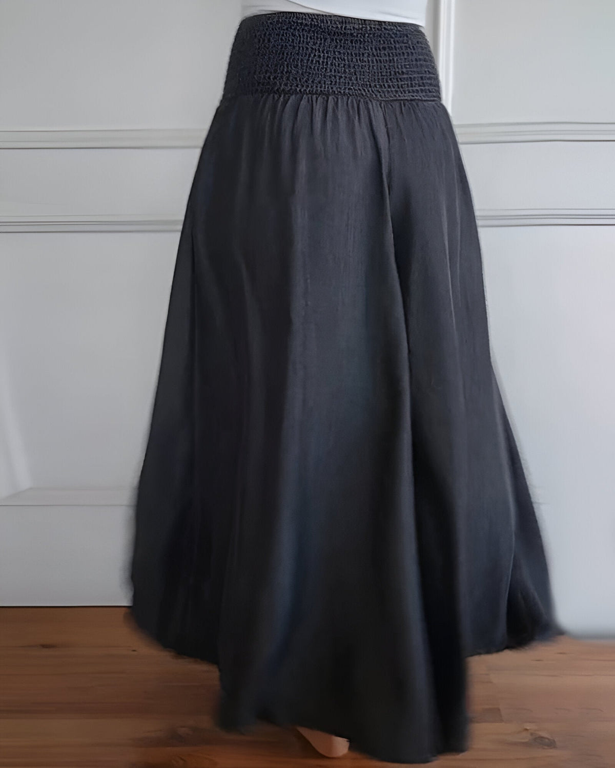 Pantalon fluide gris foncé à taille élastique froncée, jambes larges et longues.