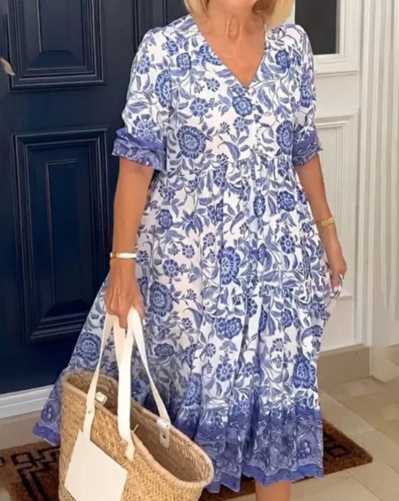 Robe d’été bleue imprimée fleurs, col en V, manches courtes bouffantes, longueur midi.