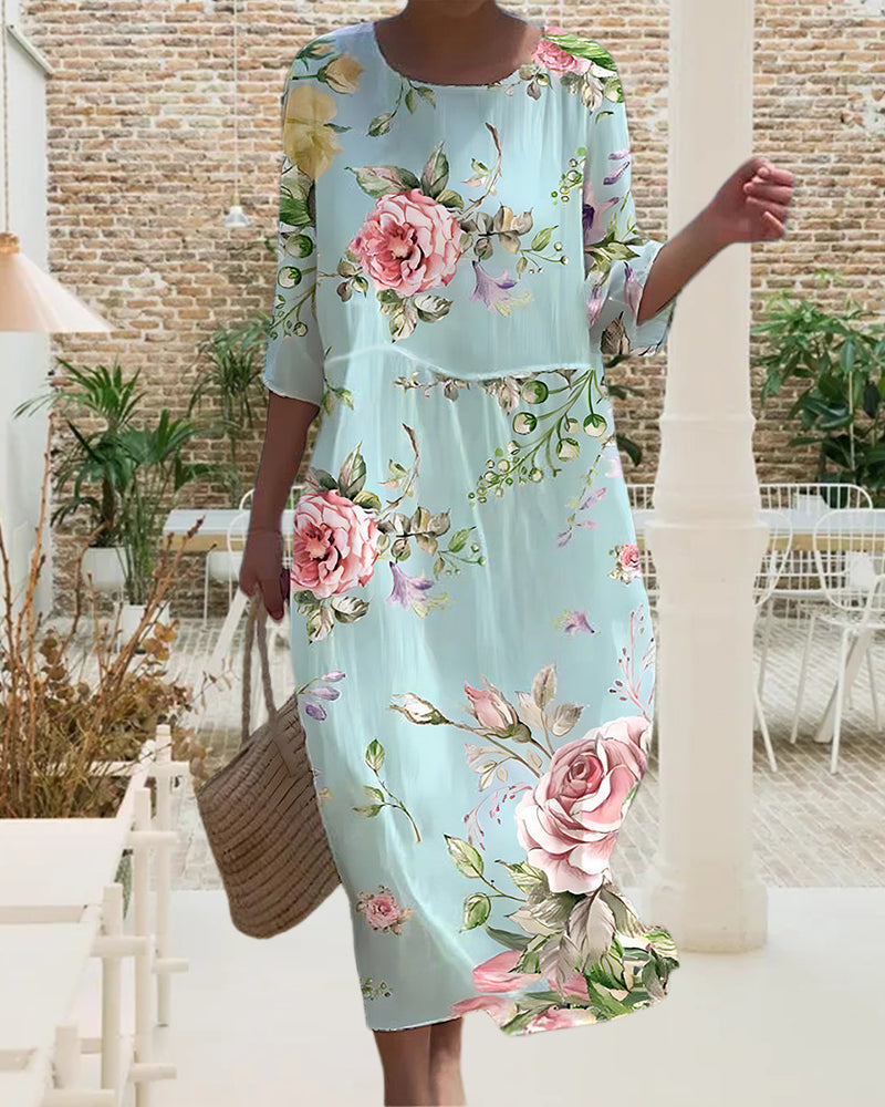 Robe mi-longue bleu clair à grandes fleurs roses, col rond, manches 3/4