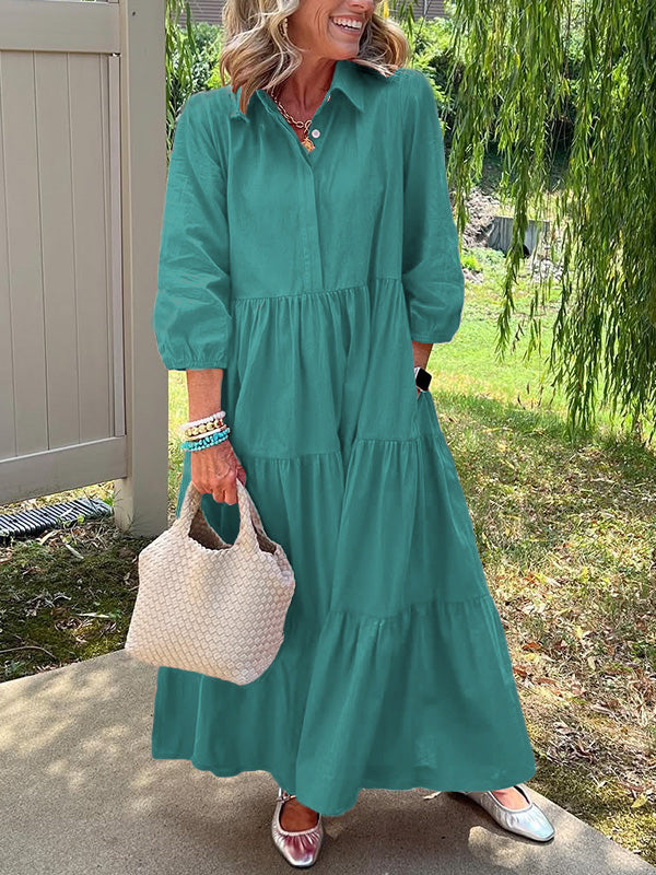 Robe longue vert émeraude à col boutonné, manches bouffantes, volants et coupe fluide.