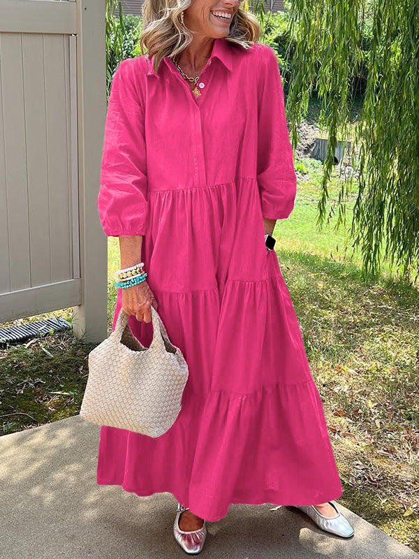 Robe longue rose vif à col boutonné, manches bouffantes, superposition de volants.