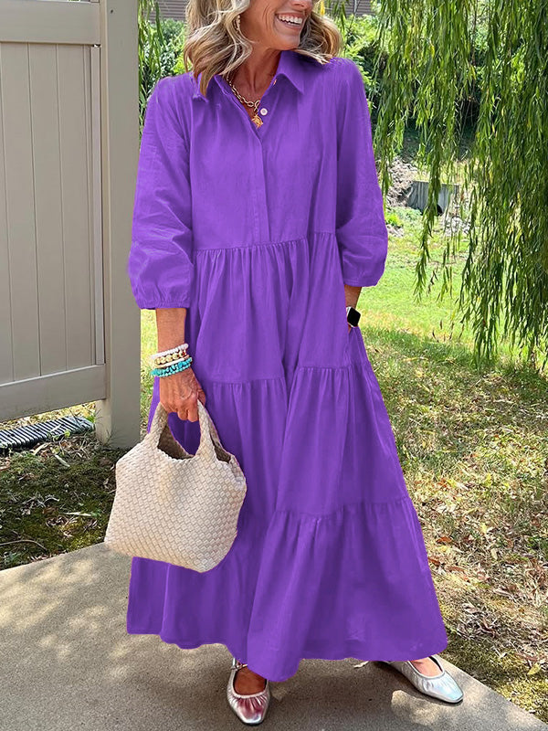 Robe longue violette à col boutonné, manches bouffantes, taille marquée et volants.