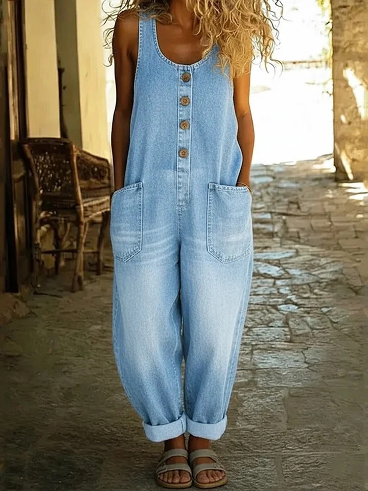 Combinaison en jean bleu clair sans manches, boutons devant, poches poitrine et latérales, jambes larges.