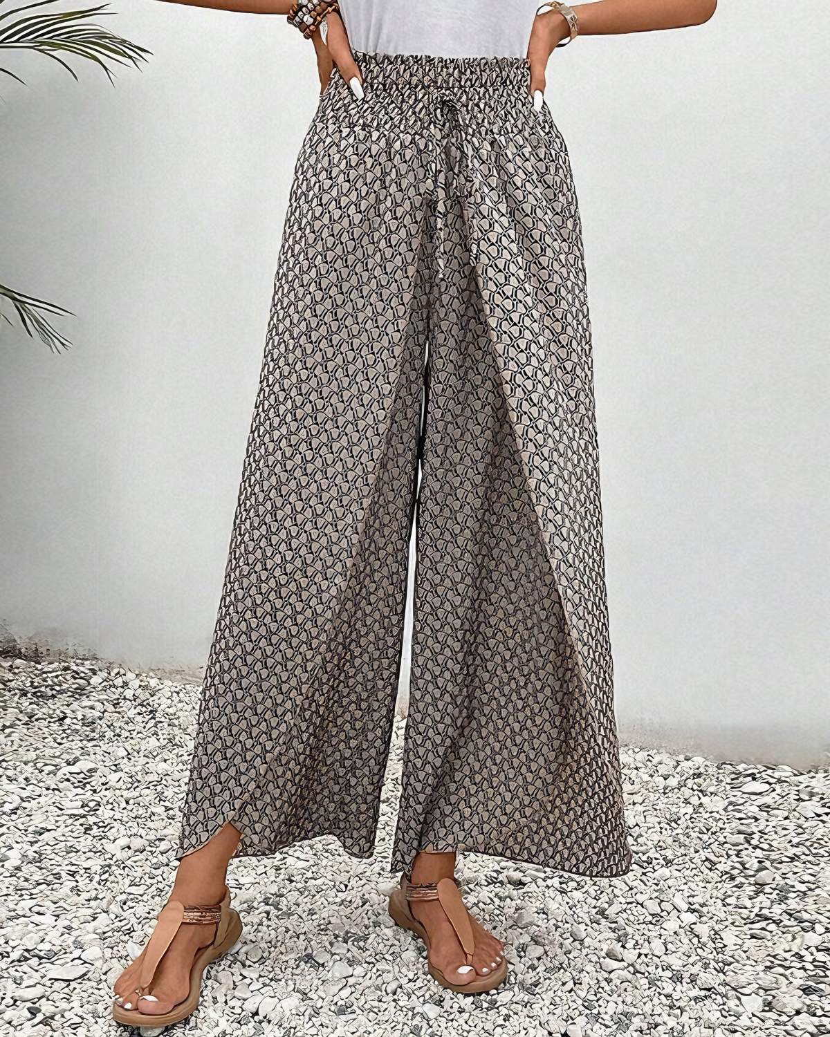 Pantalon large à taille froncée élastique, imprimé répétitif gris et blanc.