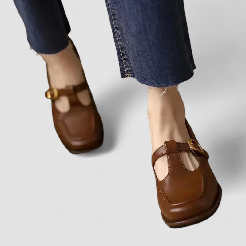 Chaussures bébé à talon bas en cuir brun avec bride et boucle dorée.
