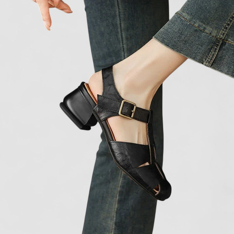 Chaussures bébé noires, bride à boucle, empeigne à découpes et talon bloc