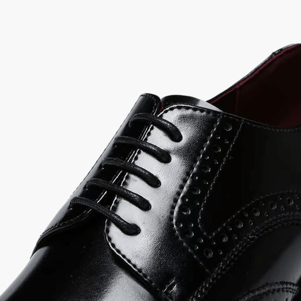Chaussure habillée homme noire en cuir, à lacets, perforations décoratives, détail du cou-de-pied.