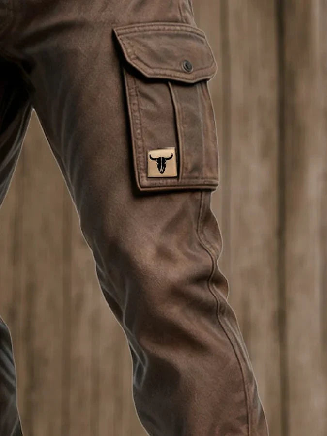 Pantalon cargo brun foncé avec poche boutonnée et écusson logo sur la jambe.