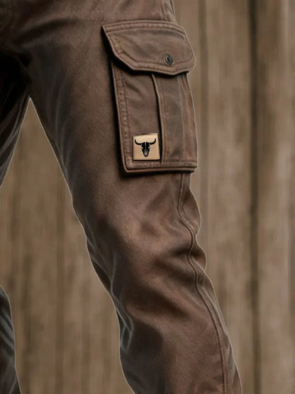 Pantalon cargo brun foncé avec poche boutonnée et écusson logo sur la jambe.