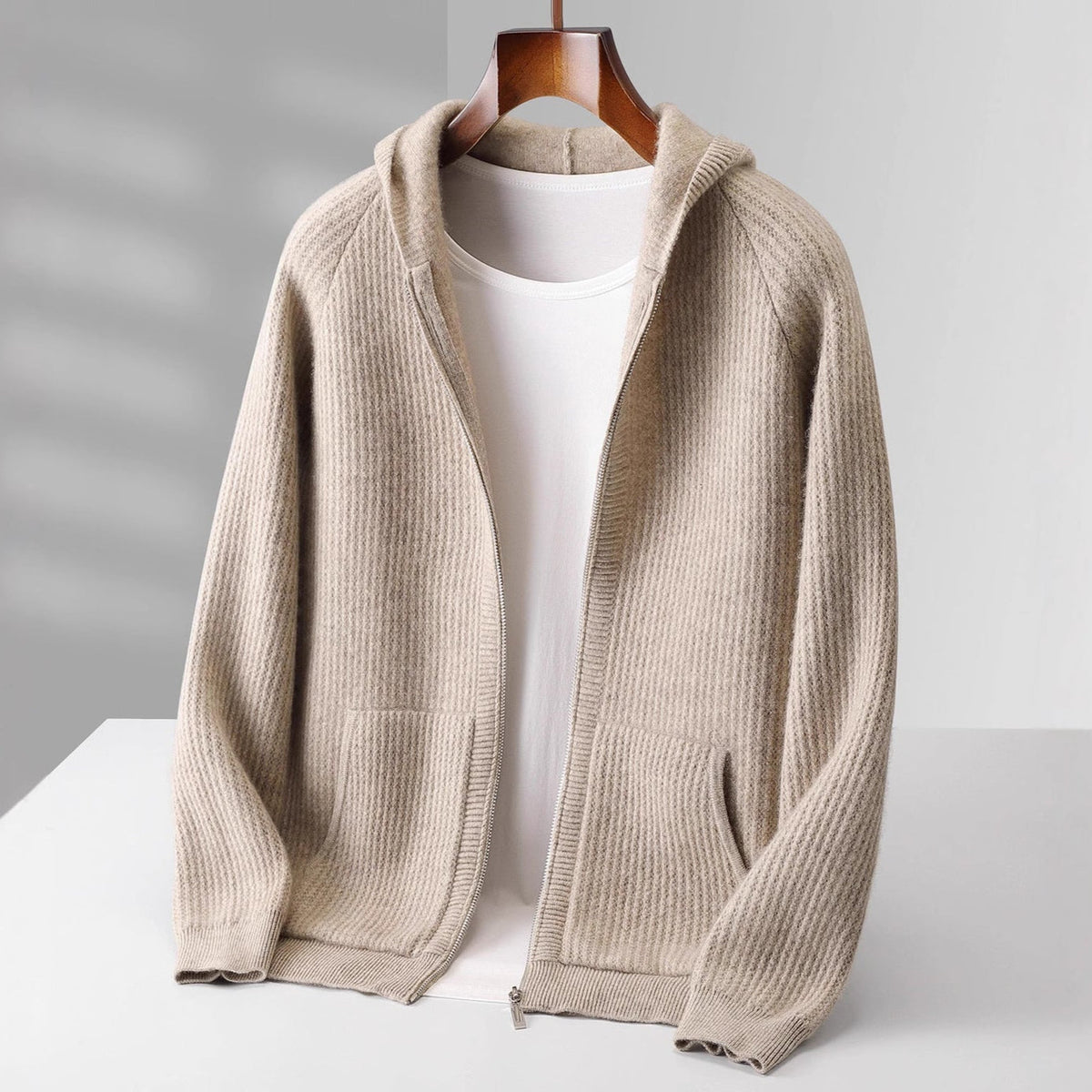 Sweat à capuche en cachemire beige, zip intégral et poche kangourou.