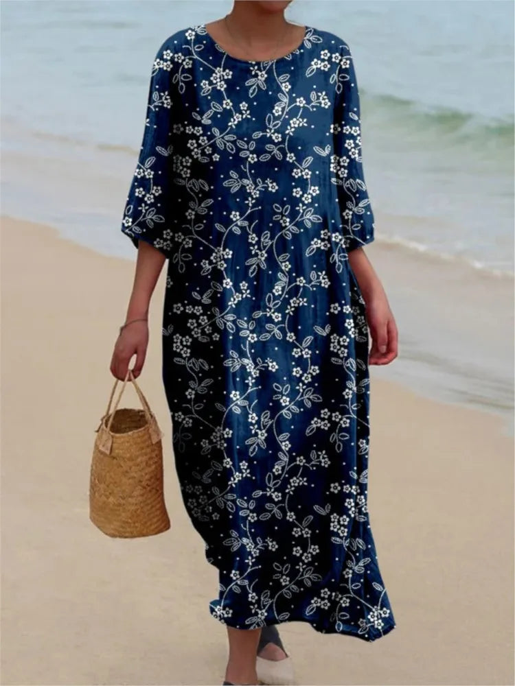 Robe vintage longue bleu marine à fleurs blanches, encolure ronde, manches évasées.