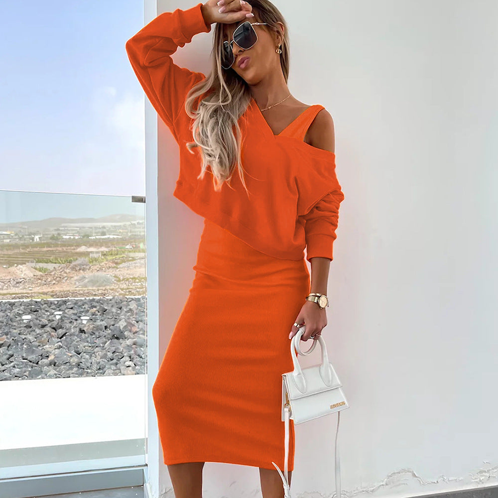 Robe midi orange à épaules dénudées et manches longues, coupe près du corps.