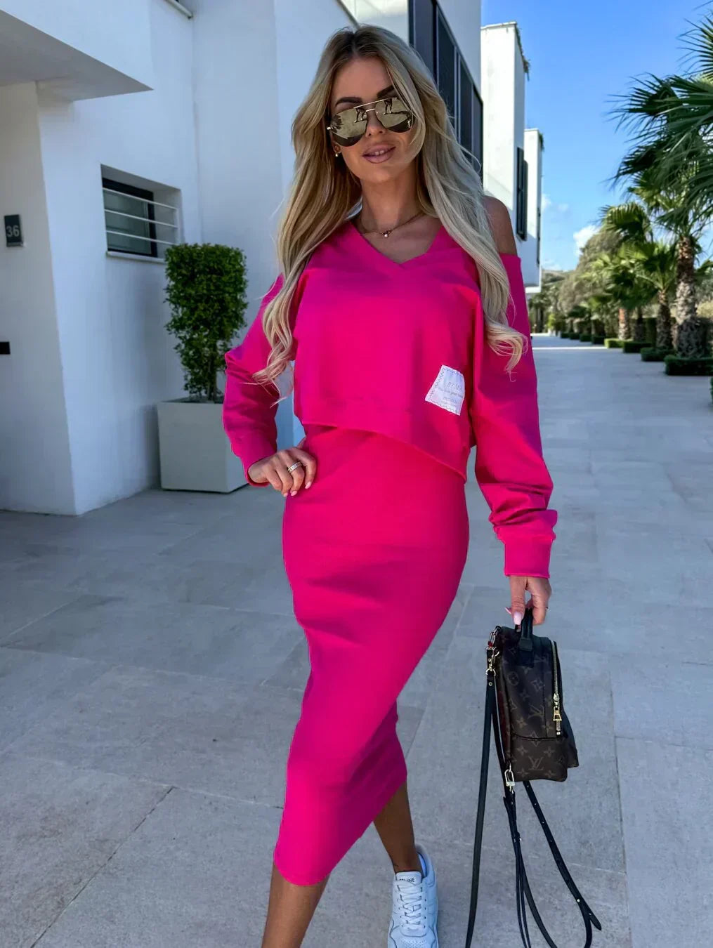 Robe midi rose fuchsia à manches longues, décolleté en V, coupe près du corps.
