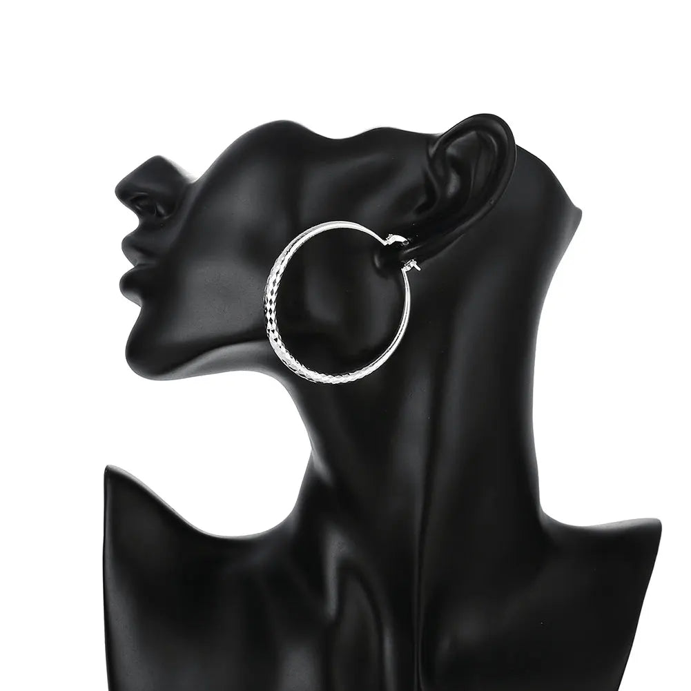 Boucles d’oreilles créoles en argent sterling, anneau texturé à fermoir à charnière.